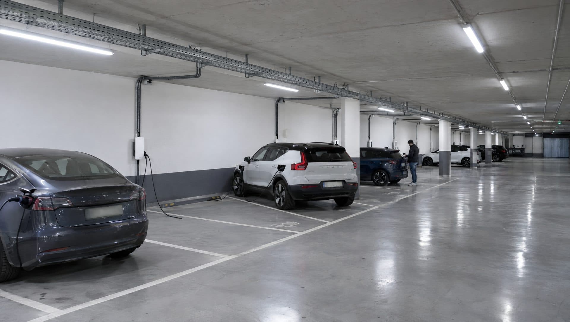 Garaje de un edificio nuevo con bandeja continua por el techo y derivaciones a plazas con cargadores y coches enchufados